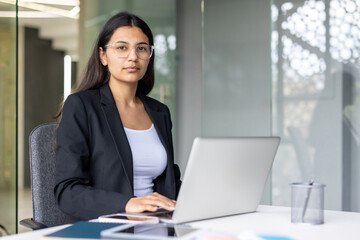 Young businesswoman working on laptop in modern office