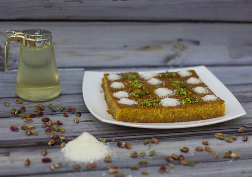 Traditional Basbousa Cake topped with Pistachio and Coconut powder in plate side view of Middle Eastern Sweet