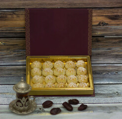 Maamoul Tamr Filled with Dateand dusted with powdered sugar in box with tea side view of Delicious Middle Eastern dessert