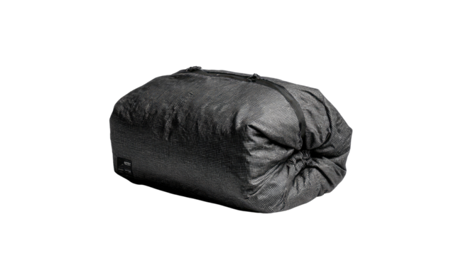 Dark gray, oblong, fabric duffel bag.  Compressible, drawstring closure