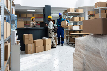 Diverse warehouse team using bar code scanners to manage packages and inventory. Industrial staff...
