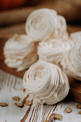 Homemade pumpkin marshmallows on rustic wooden table with seeds and autumn decor