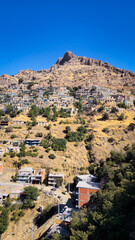 Obraz premium Stone houses rise across a rugged mountain slope under a clear sky — a striking rural scene shaped by elevation, texture, and human adaptation. 📍Hawraman Takht, Kurdistan 