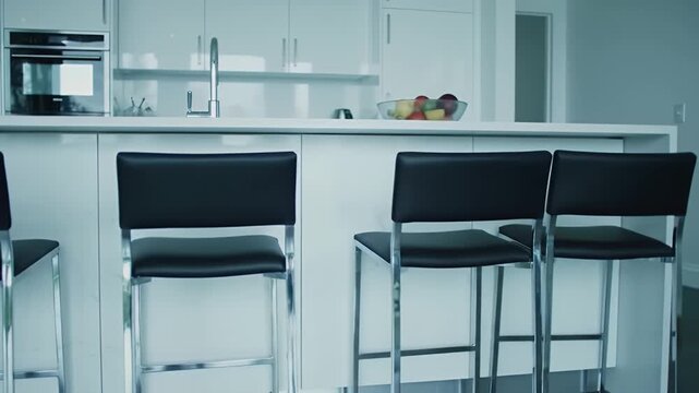 Modern Kitchen Interior with White Cabinets and Bar Stools and Fruit Bowl