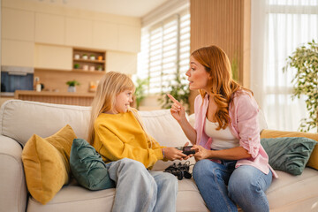 Mother scolding daughter for playing video games at home