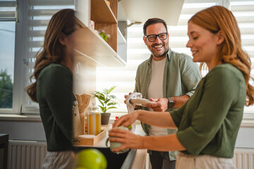 Happy couple washing dishes together in modern kitchen