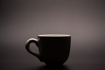 Cup, beautiful cup alone placed on a dark background, selective focus.