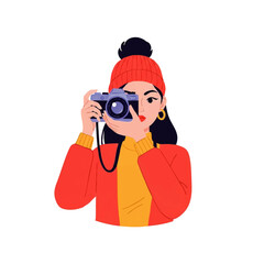 Young woman in winter hat taking a photo with a camera.