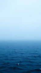 Fototapeta premium Misty Ocean Horizon Blue and Gray Water Under a Calm Sky vertical