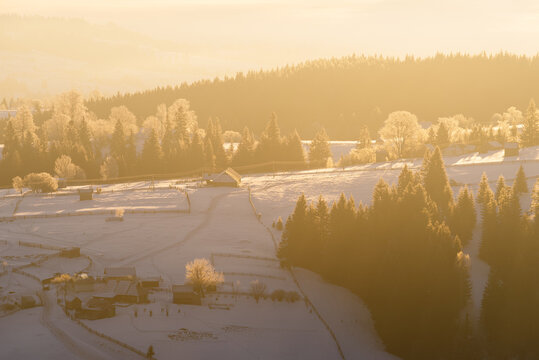 Winter Mountain Village At Sunrise With Snowy Slopes And Frosted Trees