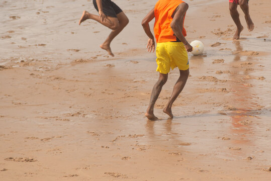 Men are seen on Ondina beach taking part in a beach soccer match. Salvador city, Brazil.