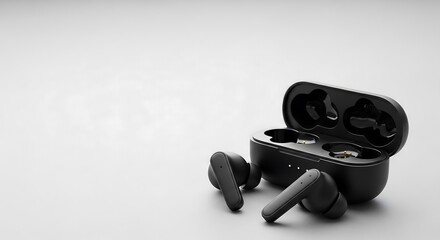 Matte black wireless earbuds on light gray background with negative space, product photography for minimalist tech branding