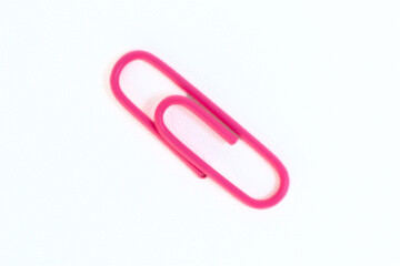 Pink paper clip on white background
