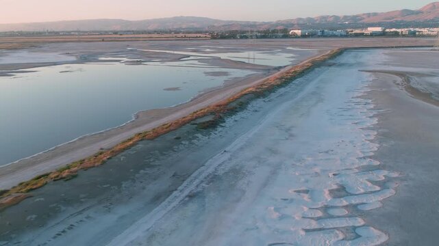 Aerial view of salt ponds in San Francisco Bay Salt Ponds, Fremont, California, USA. The ponds are used for salt production, and the different colors are due to varying salinity levels. 