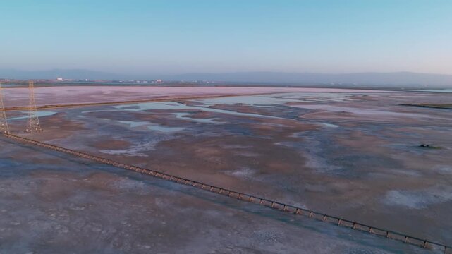 Aerial view of San Francisco Bay Salt Ponds, Fremont, California, USA, at sunset. The ponds are used for salt production, and the different colors indicate varying salinity levels.