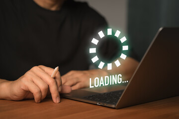 Freelance using a laptop computer with a floating Loading... progress bar, representing data processing or digital wait time in a modern tech environment, anticipation of technology responding.