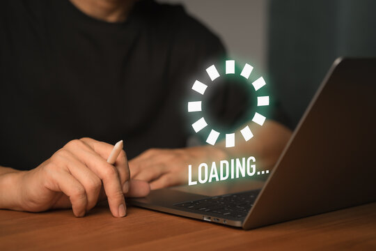 Freelance using a laptop computer with a floating Loading... progress bar, representing data processing or digital wait time in a modern tech environment, anticipation of technology responding.