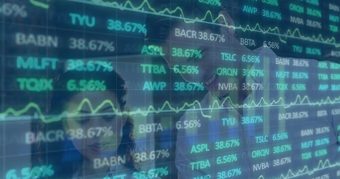 Analysts wearing business attire analyzing stock tickers in modern office, with digital screen