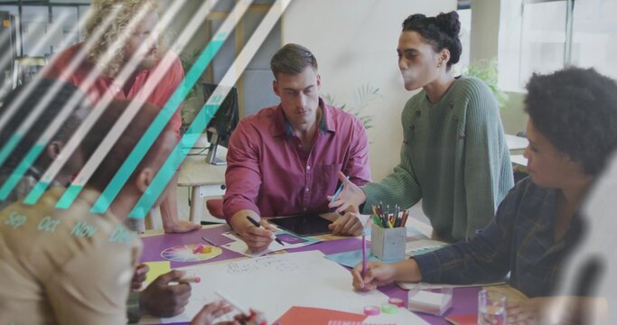 Collaborating team sketching charts on purple table in office studio, with markers and color wheel