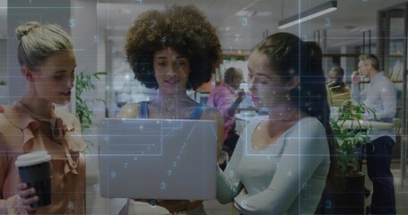 Collaborating women wearing business attire checking laptop in office, with disposable coffee cup