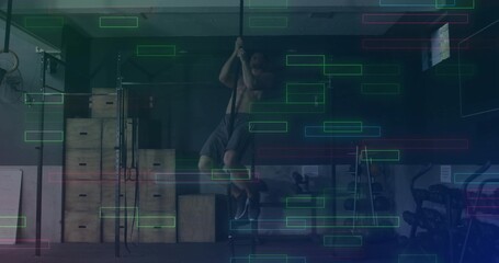 Climbing shirtless man ascending thick rope in fitness gym, with plyo boxes squat rack barbells