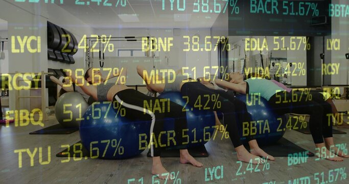 Six women performing back-extension on blue stability balls in fitness studio, with code overlay - Powered by Adobe