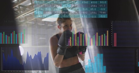 Standing female boxer wearing gloves, sports bra in boxing gym, with heavy bag, floating analytics