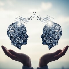 Two heads filled with gears facing each other held in hands against a bright sky background view