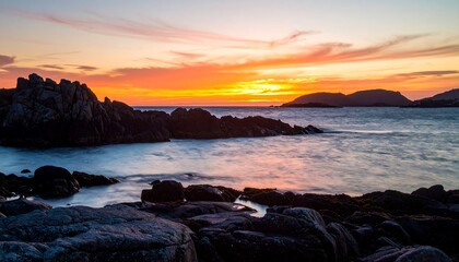 Dramatic sunset over the rocky coast, showcasing vibrant colors and tranquil seas