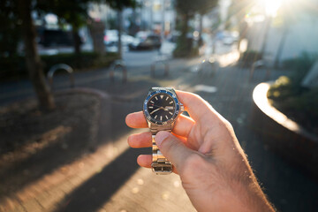 Wristwatch held up on urban street