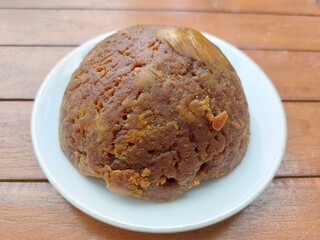 Traditional palm sugar in round shape with solid texture, natural sweetener for food and beverages.