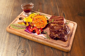 Tasty fresh Steak with herbs on Wooden desk