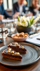 Elegant dessert presentation with chocolate tart slices, cookies, and flower centerpiece on a meeting room table.