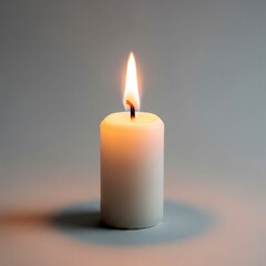 Single white wax candle burning in a gray studio, creating a soft and warm glow, perfect for creating a calm atmosphere and symbolizing hope and remembrance .