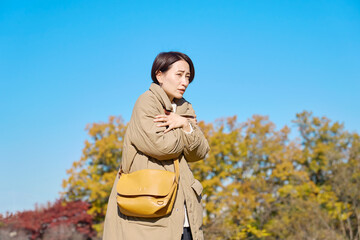 外で凍えるミドルエイジの女性