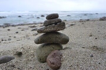 Stacked stones on sandy shore at Menganti beach Central Java Indonesia for coastal nature photography
