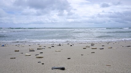 Pebbled sandy shore at Menganti beach Indonesia for serene coastal travel photography
