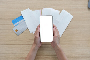 Obraz premium Digital Finance. Woman holding smartphone with blank screen over receipts and cards.