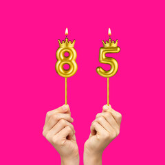 Hands holding number shaped candles - Birthday number 85