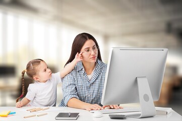 Obraz premium Mother working at home office with a cute small kid.