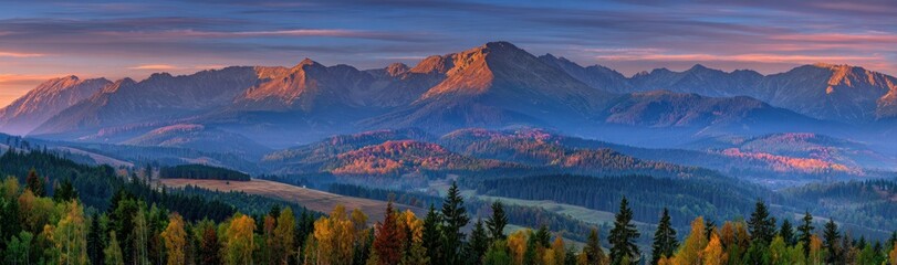 Scenic panorama of mountains and forests, glowing with warm sunset light, veiled by soft blue mist, under a colorful, streaked sky
