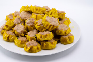 Steaming Pile of Golden Yellow Shumai Dumplings on White Plate, Asian Cuisine, Dim Sum.
