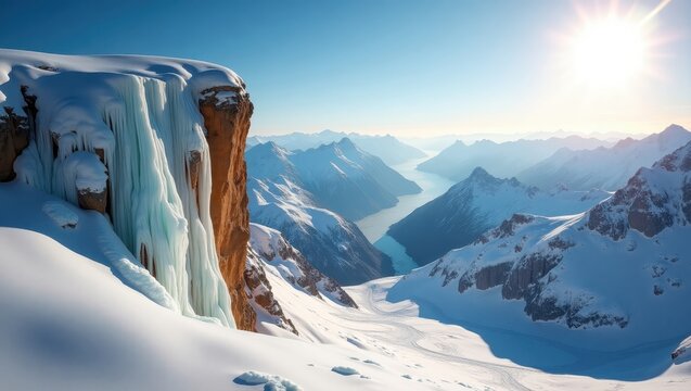 A breathtaking vista of a snowy mountain peak, showcasing an icy waterfall cascading down a sheer cliff face, with a vast expanse of snow-capped mountains and a valley below.