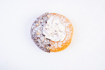 Donut with powdered sugar. One half is coated with chocolate and the other half remains plane with a golden glaze.