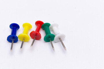 Colorful Push Pins - Blue, Yellow, Red, Green, and White on a White Background.