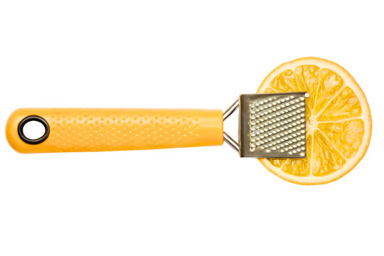 Small handheld kitchen zester grater on a fresh lemon slice isolated with transparent background