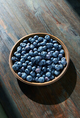 Blueberries in wooden bowl on a wooden