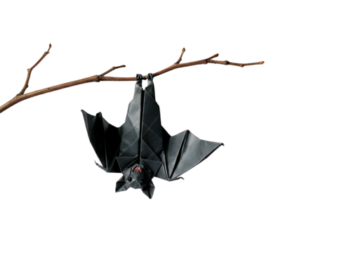 A black origami bat hanging upside down from a branch against a white background.