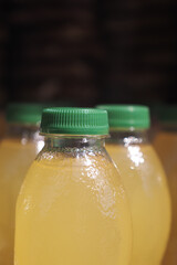 Refreshing yellow beverage in green capped bottles