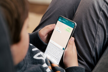 Little boy showing a phone in his hand and chatting app on the screen. Child care. Communication Technology, application.
